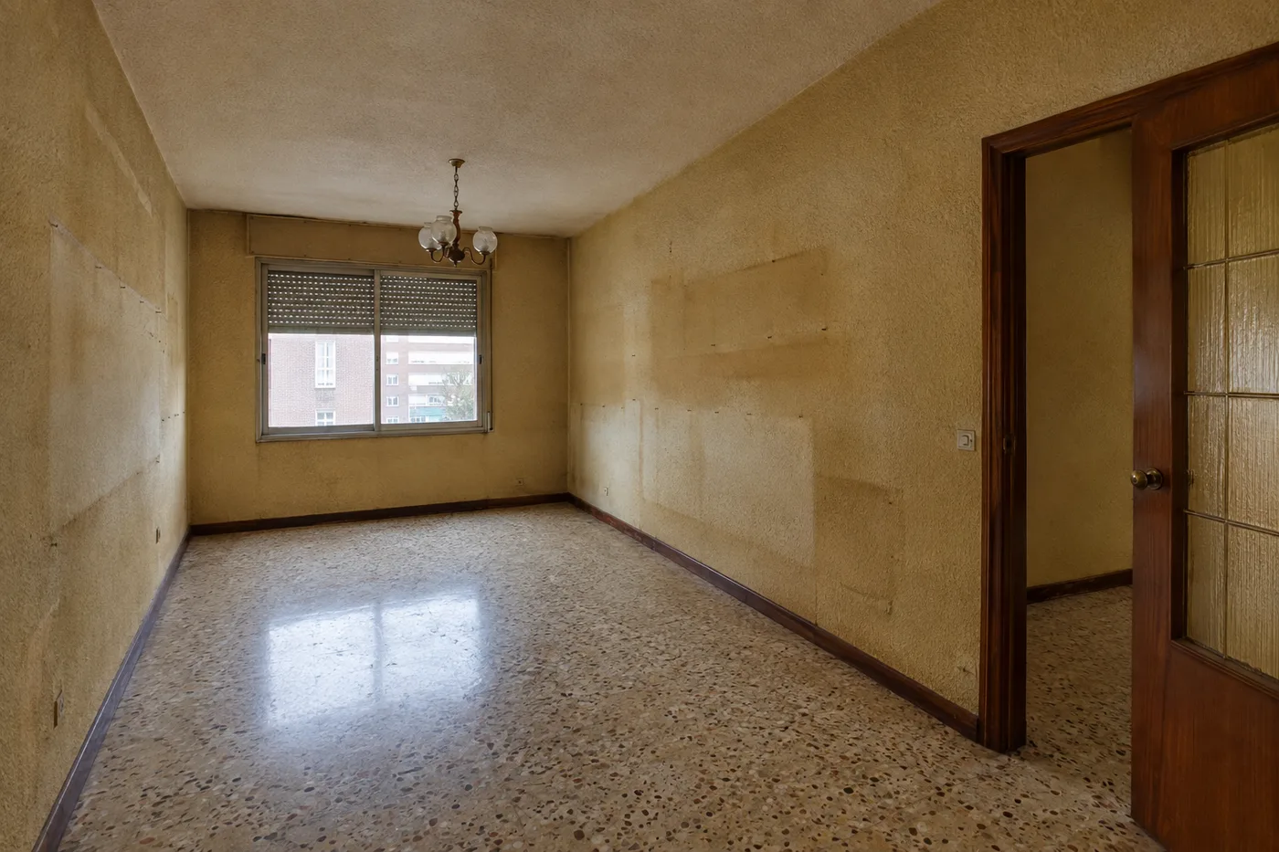 Salón sin reformar, con gotelé y suelo de terrazo